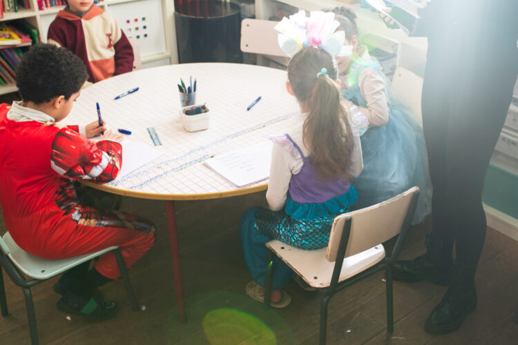 Petit groupe d'élèves multi-niveaux en projet collaboratif à l'école Arborescences